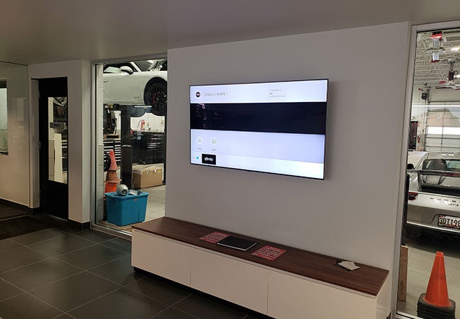 A large TV mounted on the wall in a modern living room setting.